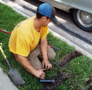 Coppell sprinkler repair technician installs new Hunter sprinkler head and attached line